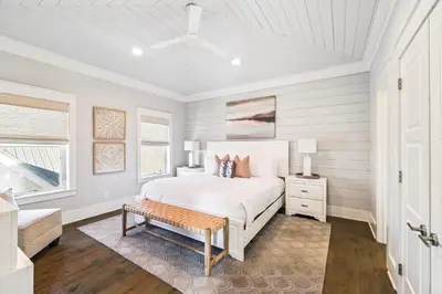a white bedroom with a bed and a bench at Casablanca By The Sea by 30A Escapes in Rosemary Beach