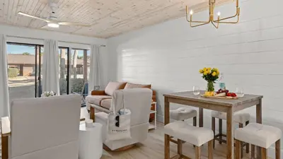 a living room with a table and chairs at Sandbar Serenade by AvantStay Beachside Home Pool Tennis Court Beach Access Near Pier Park in Panama City Beach