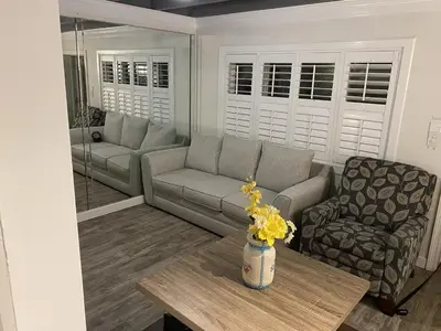 a living room with a couch and a table at Tiny home living!! First floor condo! in Panama City Beach