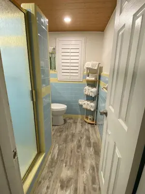 a bathroom with a toilet and blue tile at Tiny home living!! First floor condo! in Panama City Beach