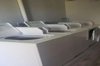 a row of empty washing machines in a room at Tiny home living!! First floor condo! in Panama City Beach