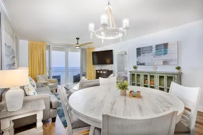 a living room with a dining room table and a couch at Emerald Beach 2030 by Emerald Coast Retreats in Panama City Beach