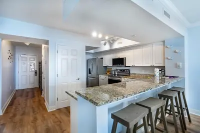 a kitchen with a large counter with stools in it at Emerald Beach 2030 by Emerald Coast Retreats in Panama City Beach