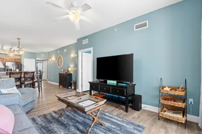 a living room with a couch and a tv at Sunrise Beach 17th Floor 3BR Condo | Oversized Balcony, Heated Pool, Near Pier Park in Panama City Beach