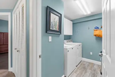 a laundry room with blue walls and a washer and dryer at Sunrise Beach 17th Floor 3BR Condo | Oversized Balcony, Heated Pool, Near Pier Park in Panama City Beach