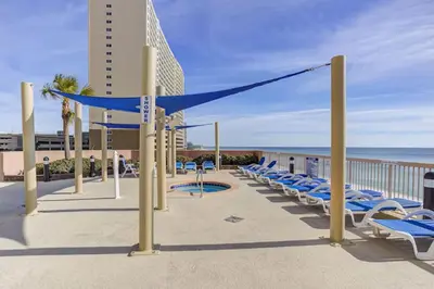 a row of lounge chairs on a balcony with the beach at Sunrise Beach 17th Floor 3BR Condo | Oversized Balcony, Heated Pool, Near Pier Park in Panama City Beach