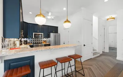 a kitchen with black cabinets and orange bar stools at 30A Stars and Stripes in Seagrove Beach
