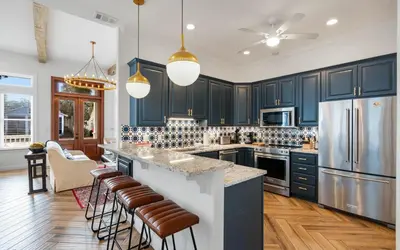 a kitchen with navy blue cabinets and stainless steel appliances at 30A Stars and Stripes in Seagrove Beach