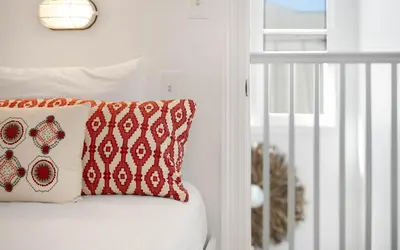 a white bed with a red and white pillow at 30A Stars and Stripes in Seagrove Beach