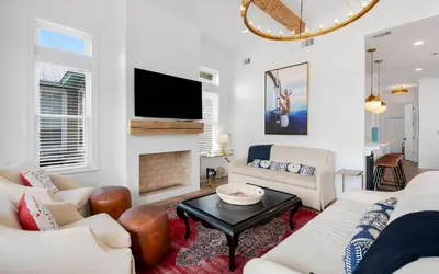 a living room with white furniture and a flat screen tv at 30A Stars and Stripes in Seagrove Beach