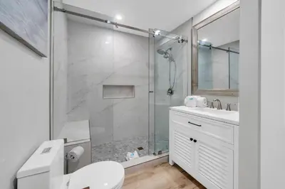 a bathroom with a shower and a toilet and a sink at Pelican's Roost in Santa Rosa Beach