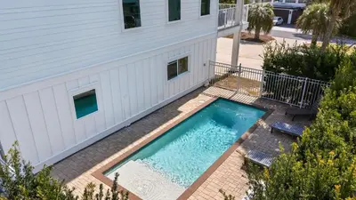 an overhead view of a swimming pool next to a building at Sandy Pelican by AvantStay Exclusive Beach Access Private Pool Firepit Balcony Sunset Views in Seacrest