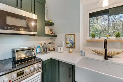 a kitchen with green cabinets and a stove top oven at Near Hiking! Angler Oasis with Hot Tub in Florida