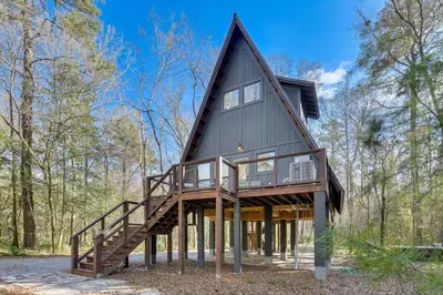 a frame house with a gambrel roof and wooden stairs at Near Hiking! Angler Oasis with Hot Tub in Florida