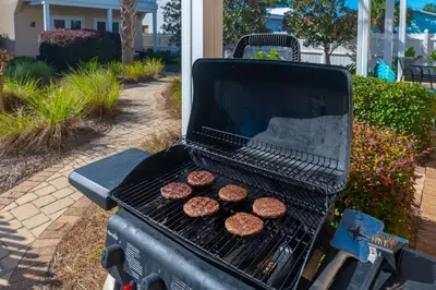 two hamburgers are cooking on a grill at Beach Getaway for 15 A Few Steps from the Sand in Panama City Beach