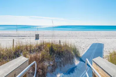 a view of a beach with two benches and the ocean at Beach Getaway for 15 A Few Steps from the Sand in Panama City Beach