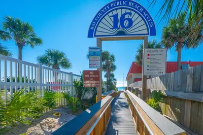 a sign for a hotel on a beach with palm trees at Beach Getaway for 15 A Few Steps from the Sand in Panama City Beach