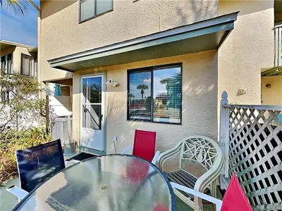 a glass table and chairs on a balcony with a house at Gulf Highlands #195 in Panama City Beach