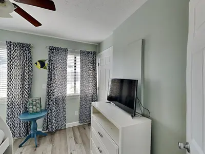 a living room with a tv and a blue stool at Gulf Highlands #195 in Panama City Beach