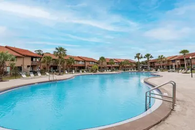 a swimming pool at a resort with chairs and condos at Gulf Highlands #195 in Panama City Beach