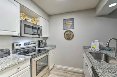 a kitchen with white cabinets and a stove top oven at 30As Favorite Beach Condo- 6 min walk to the beach in Santa Rosa Beach