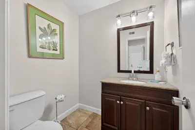 a bathroom with a toilet and a sink and a mirror at Emerald Escape 1 - 3 Blocks to Beach in Panama City Beach