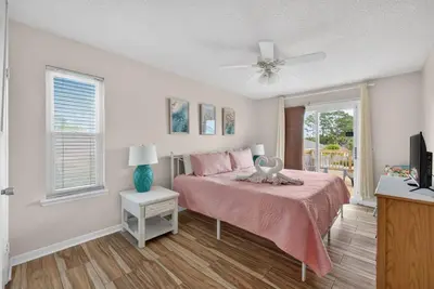 a bedroom with a bed with pink sheets and a fan at Emerald Escape - 3 Blocks to Beach in Panama City Beach