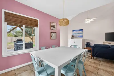 a dining room and living room with a white table and chairs at Emerald Escape - 3 Blocks to Beach in Panama City Beach