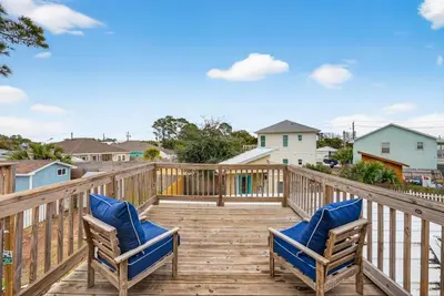 a wooden deck with two chairs on it at Emerald Escape - 3 Blocks to Beach in Panama City Beach