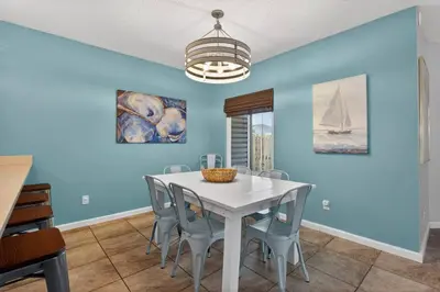 a dining room with blue walls and a white table and chairs at Emerald Escape - 3 Blocks to Beach in Panama City Beach