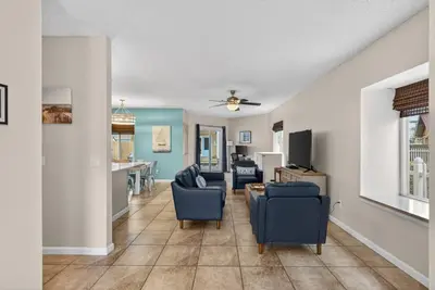 a living room with blue chairs and a table at Emerald Escape 2 - 3 Blocks to Beach in Panama City Beach