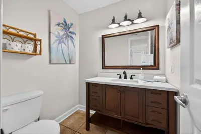 a bathroom with a sink and a toilet and a mirror at Emerald Escape 2 - 3 Blocks to Beach in Panama City Beach