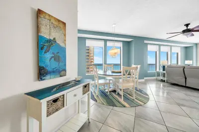 a dining room with a table and a couch at Seychelles 701 by Emerald Coast Retreats in Panama City Beach