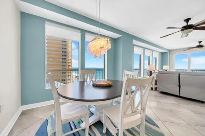 a dining room with a table and chairs at Seychelles 701 by Emerald Coast Retreats in Panama City Beach