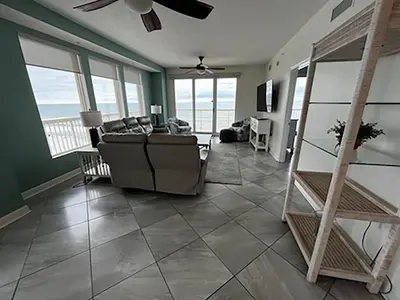a living room with a couch and some windows at Seychelles 701 by Emerald Coast Retreats in Panama City Beach