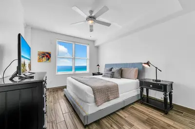 a bedroom with a bed and a flat screen tv at Aqua Resort 2003 in Panama City Beach
