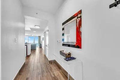 a living room with white walls and a hardwood floor at Aqua Resort 2003 in Panama City Beach