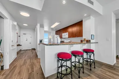 a kitchen with red stools at a counter at Aqua Resort 2003 in Panama City Beach
