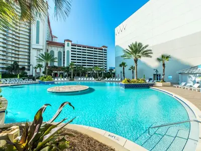 a large swimming pool with palm trees and buildings at Laketown Wharf Beach Resort in Panama City Beach