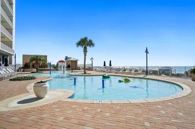 a large swimming pool in a plaza with palm trees at Laketown Wharf Beach Resort in Panama City Beach