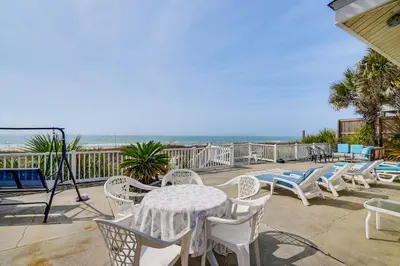 a patio with a table and chairs and the beach at Two by Sea Beachfront Private Home with Courtyard! in Panama City Beach