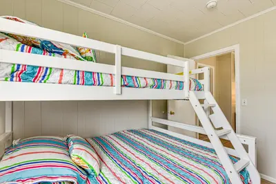 a bedroom with two bunk beds and a ladder at Two by Sea Beachfront Private Home with Courtyard! in Panama City Beach