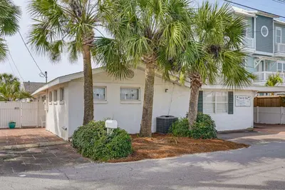 a white house with palm trees in front of it at Two by Sea Beachfront Private Home with Courtyard! in Panama City Beach