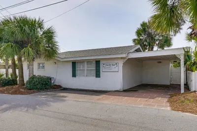 a white house with palm trees in front of it at Two by Sea Beachfront Private Home with Courtyard! in Panama City Beach