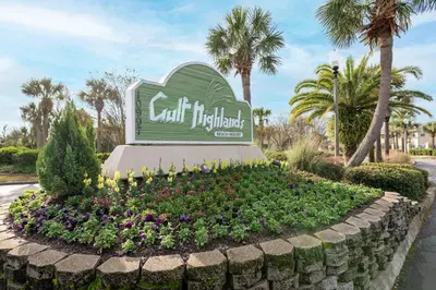 a sign at the entrance to a resort with flowers at Gulf Highlands #134F in Panama City Beach