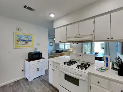 a kitchen with white cabinets and a stove top oven at Gulf Highlands #134F in Panama City Beach