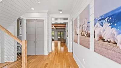 a hallway with white walls and pictures on the wall at Southern Sol in Watersound Beach