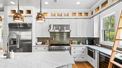 a kitchen with white cabinets and stainless steel appliances at Southern Sol in Watersound Beach
