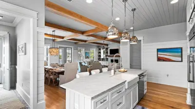 a kitchen and dining room with white walls and wood ceilings at Southern Sol in Watersound Beach