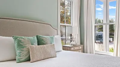 a bedroom with a bed with pillows and a window at Southern Sol in Watersound Beach